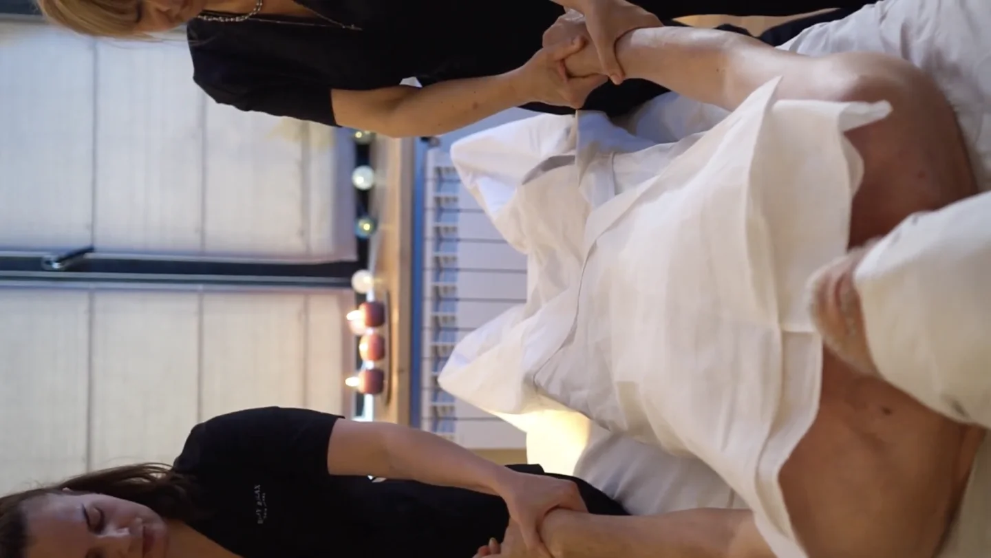 Twee masseurs behandelen tegelijkertijd de armen